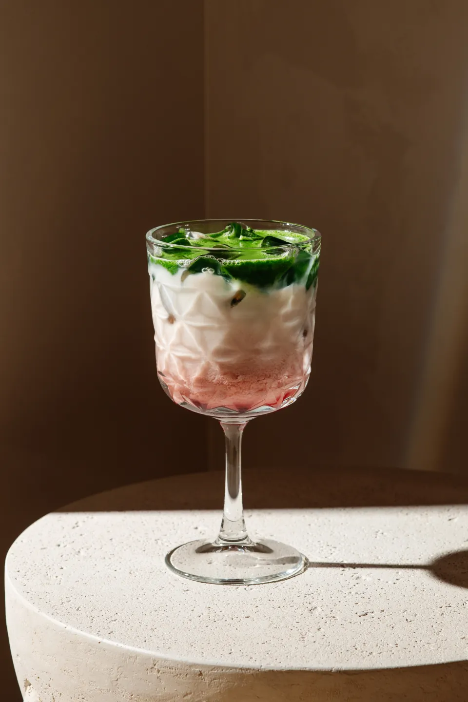 A layered pink and green iced matcha drink